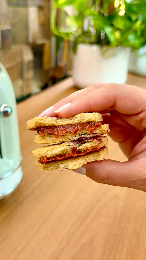 Biscoitos recheados de goiabada, um deles mordido